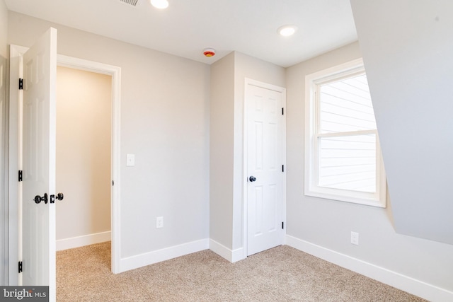 unfurnished bedroom featuring light colored carpet and a closet