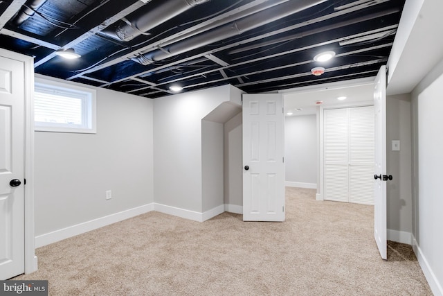 basement featuring light carpet