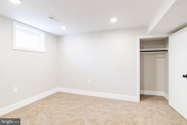 unfurnished bedroom featuring light colored carpet and a closet