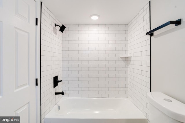 bathroom featuring toilet and tiled shower / bath combo