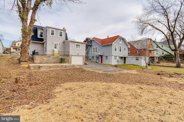 rear view of property with a garage