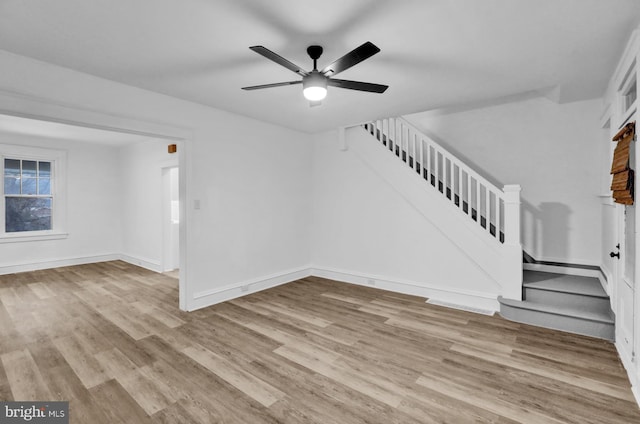 unfurnished living room featuring ceiling fan and light wood-type flooring