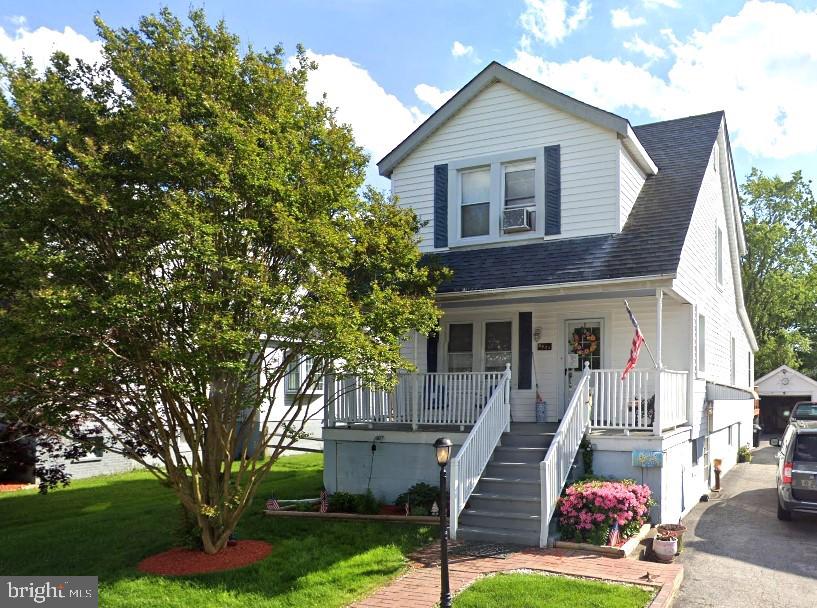 view of front of property with covered porch and a front yard