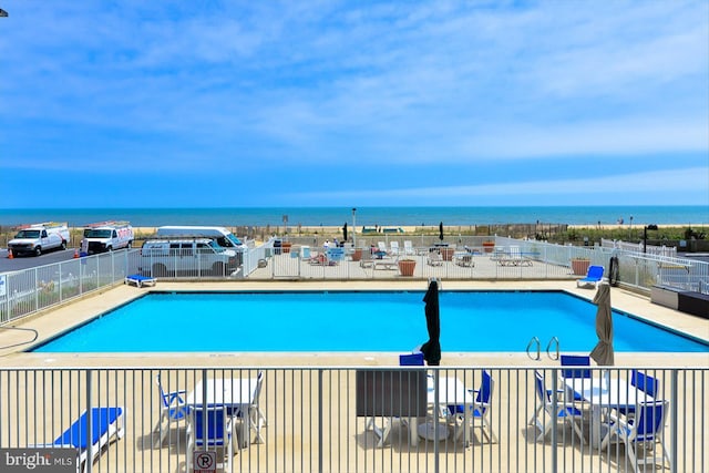 view of swimming pool with a water view and a patio area