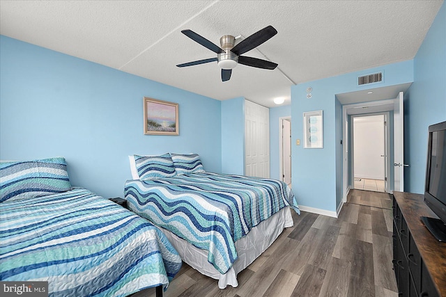 bedroom with ceiling fan, wood-type flooring, a closet, and a textured ceiling