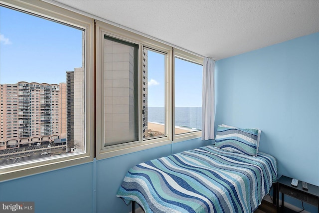 bedroom featuring a textured ceiling and a water view