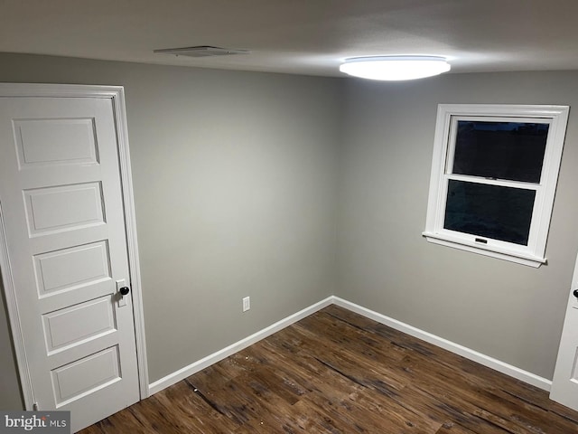 unfurnished room with dark hardwood / wood-style flooring