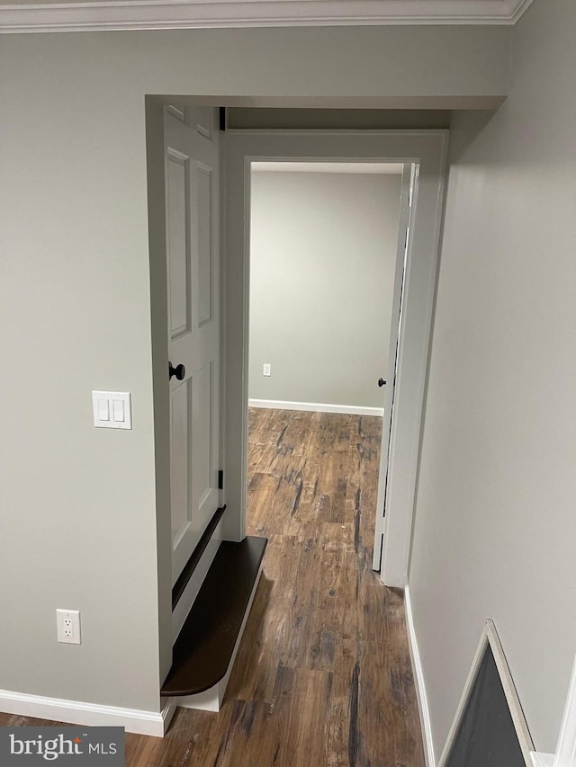 hallway with crown molding and dark hardwood / wood-style flooring