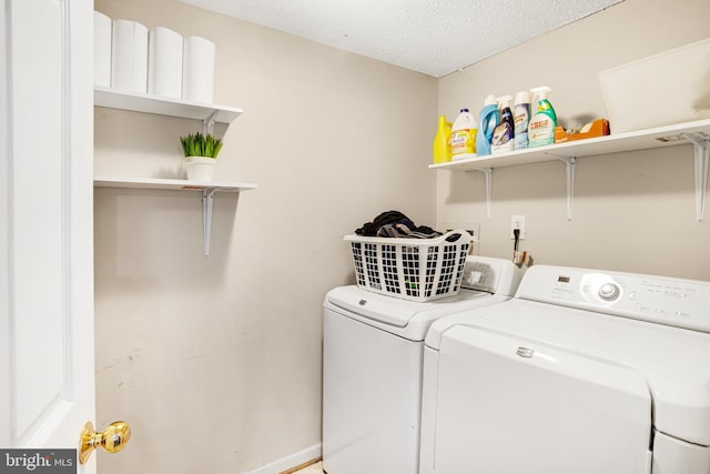 laundry area featuring washer and clothes dryer and a textured ceiling