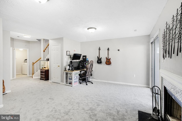 office with a tiled fireplace, washer / clothes dryer, a textured ceiling, and carpet