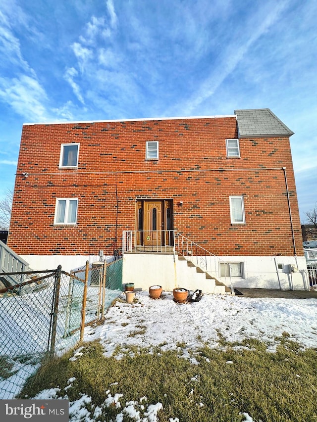 view of snow covered rear of property