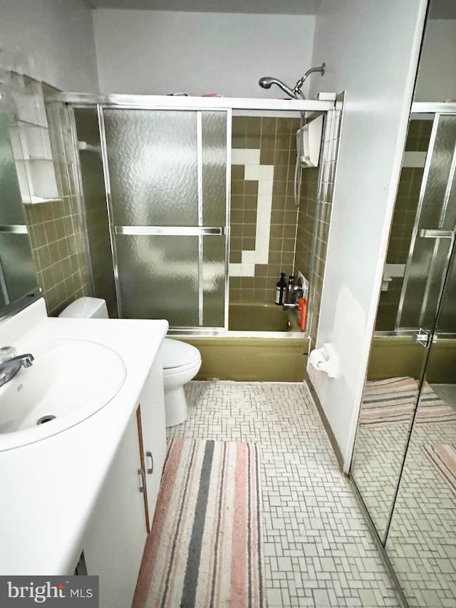 full bathroom with vanity, tile patterned floors, shower / bath combination with glass door, and toilet