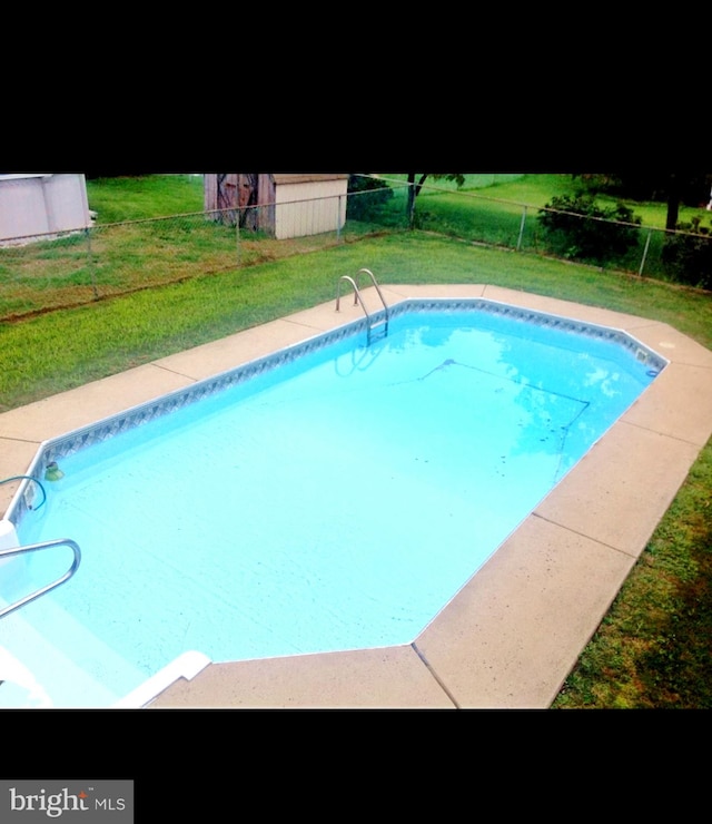 view of pool featuring a lawn