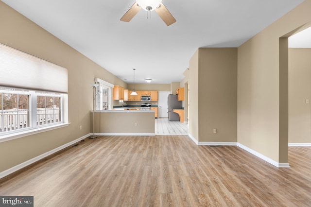 unfurnished living room with light hardwood / wood-style floors and ceiling fan