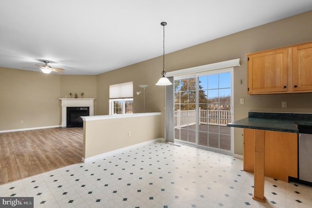 kitchen with ceiling fan, pendant lighting, and a high end fireplace