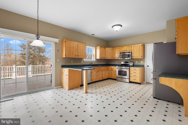 kitchen featuring sink, decorative light fixtures, and appliances with stainless steel finishes