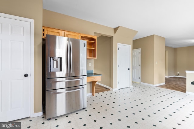 kitchen with stainless steel fridge and light brown cabinets