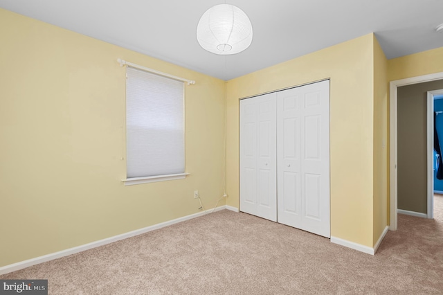 unfurnished bedroom featuring a closet and light carpet