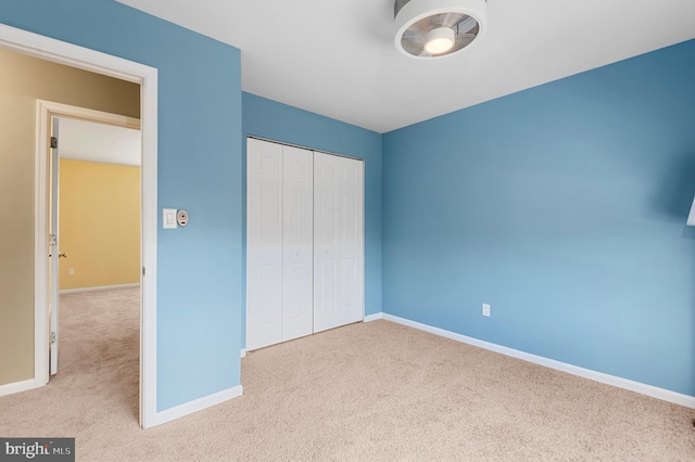 unfurnished bedroom featuring a closet and light carpet