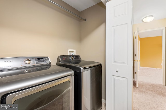 laundry area with washer and dryer and light carpet