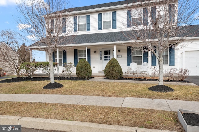 view of front facade with a garage, a front yard, and covered porch