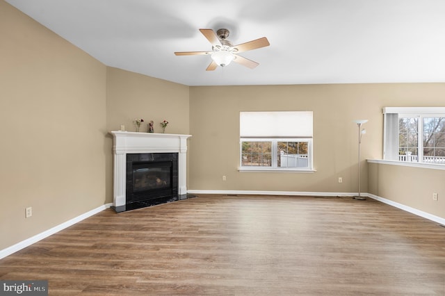 unfurnished living room with hardwood / wood-style flooring, a fireplace, and ceiling fan