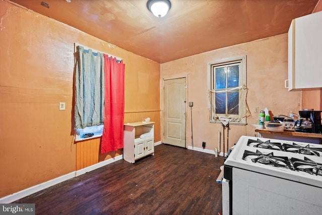 kitchen featuring white gas stove, white cabinets, and dark hardwood / wood-style flooring