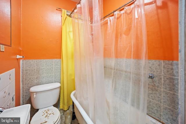 bathroom with tile walls, a shower with curtain, and toilet