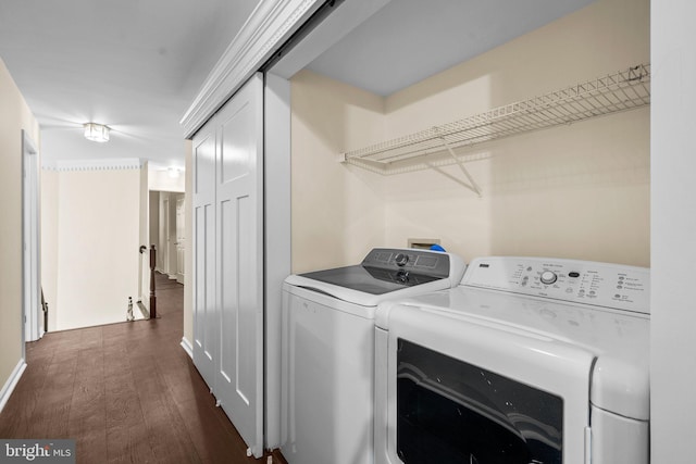 clothes washing area featuring washing machine and clothes dryer and dark hardwood / wood-style flooring