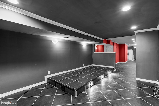 interior space featuring dark tile patterned flooring and ornamental molding