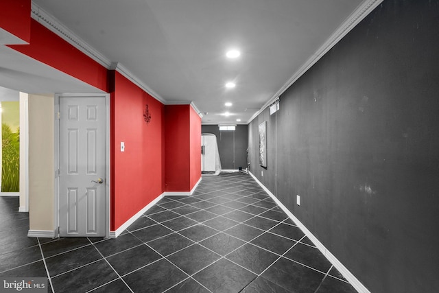 hallway with dark tile patterned floors and crown molding