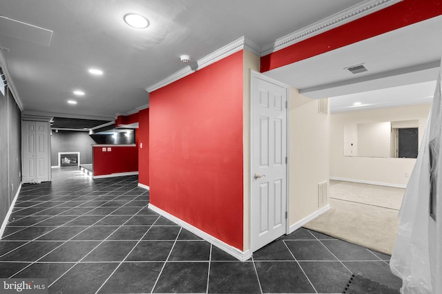 corridor featuring crown molding and dark tile patterned floors