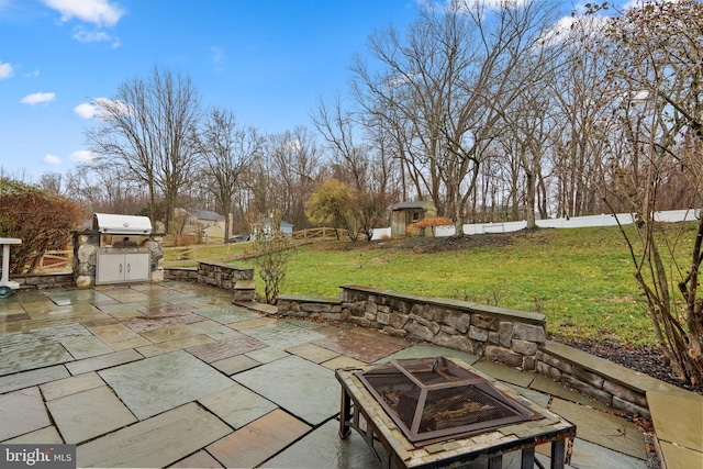 view of patio / terrace featuring a fire pit, grilling area, and exterior kitchen