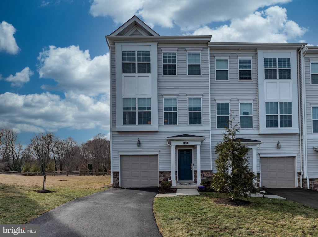 multi unit property featuring a garage and a front yard