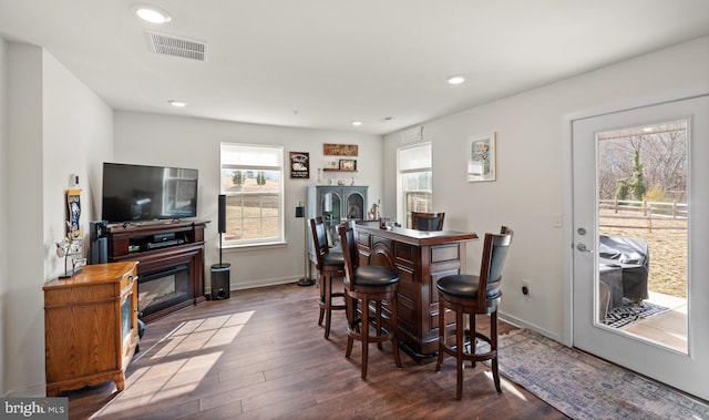 dining room with dark wood-type flooring and bar area