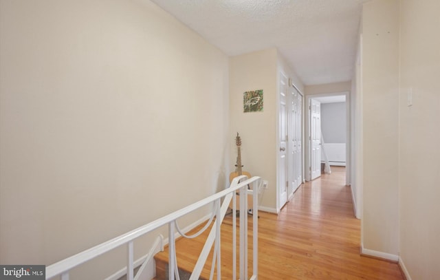 corridor featuring hardwood / wood-style floors and a textured ceiling