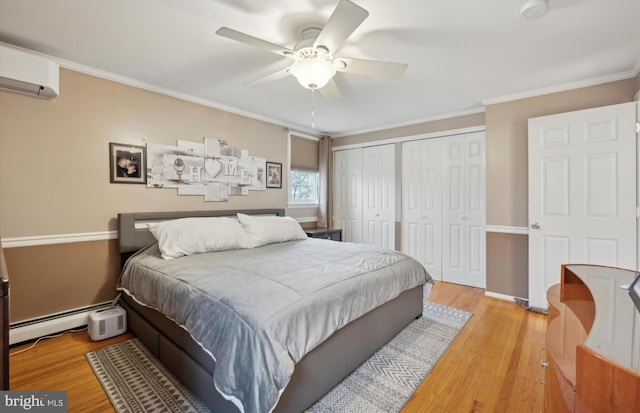 bedroom with crown molding, a baseboard heating unit, a wall unit AC, and light wood-type flooring