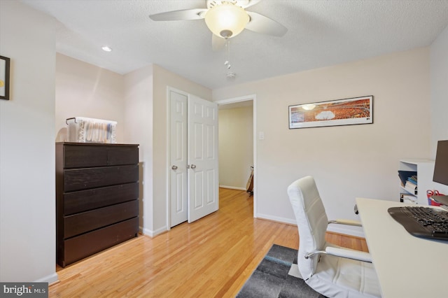 home office featuring ceiling fan, hardwood / wood-style floors, and a textured ceiling