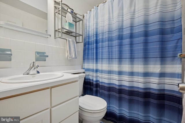 bathroom with tasteful backsplash, tile walls, vanity, toilet, and a shower with shower curtain