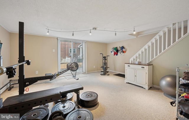 exercise room with light carpet, track lighting, ornamental molding, and a textured ceiling