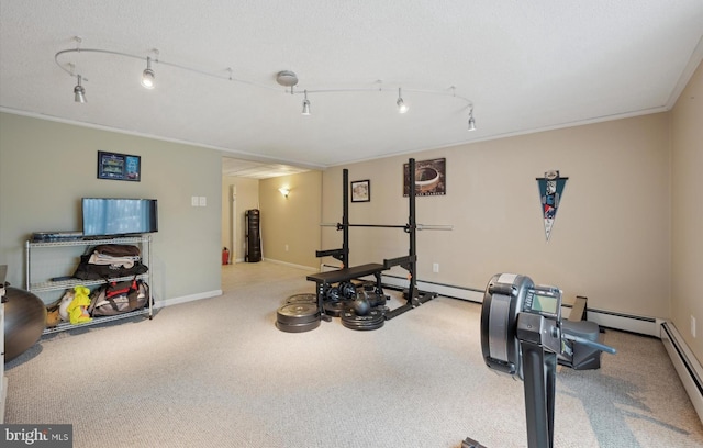 workout area featuring ornamental molding, a baseboard heating unit, and track lighting