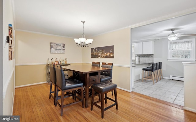 dining room with a baseboard radiator, ornamental molding, and light hardwood / wood-style floors