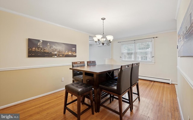 dining space with ornamental molding, a baseboard heating unit, hardwood / wood-style floors, and a chandelier