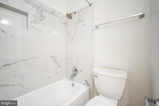 bathroom featuring tiled shower / bath combo and toilet