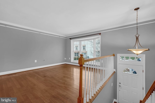 entryway with hardwood / wood-style flooring and ornamental molding