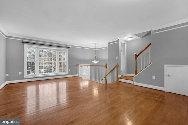 unfurnished living room with crown molding and wood-type flooring