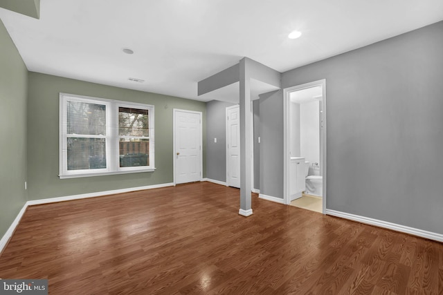 unfurnished bedroom featuring hardwood / wood-style flooring and ensuite bathroom