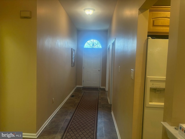 entryway with dark tile patterned floors