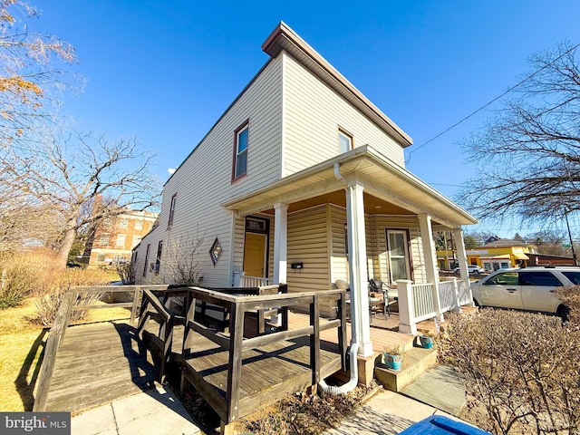 rear view of house featuring covered porch