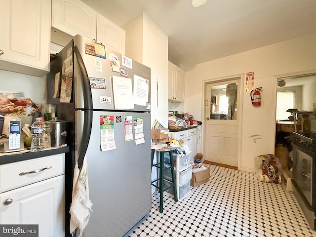 kitchen featuring white cabinetry and stainless steel fridge